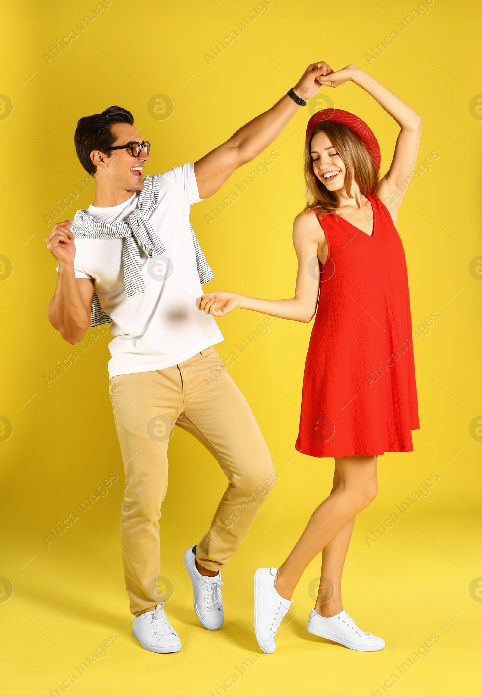 Photo of Beautiful young couple dancing on yellow background