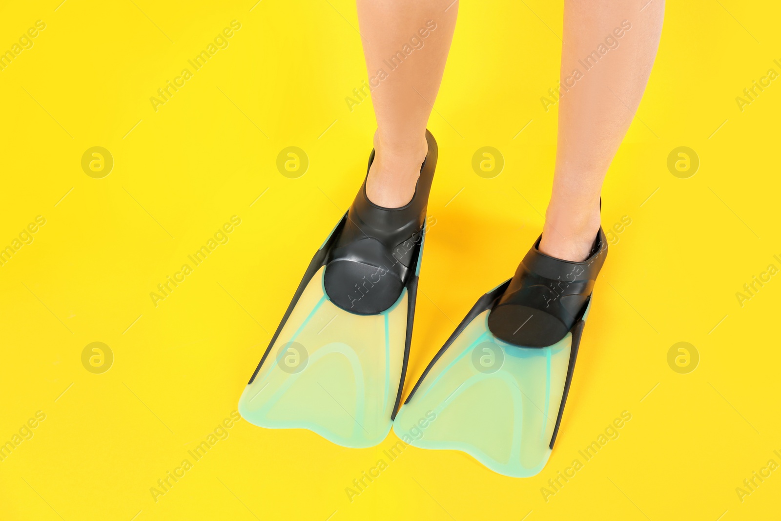 Photo of Woman in swimming flippers on color background, closeup