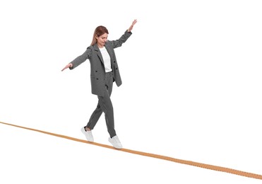 Image of Businesswoman walking rope against white background. Risk or balance concept