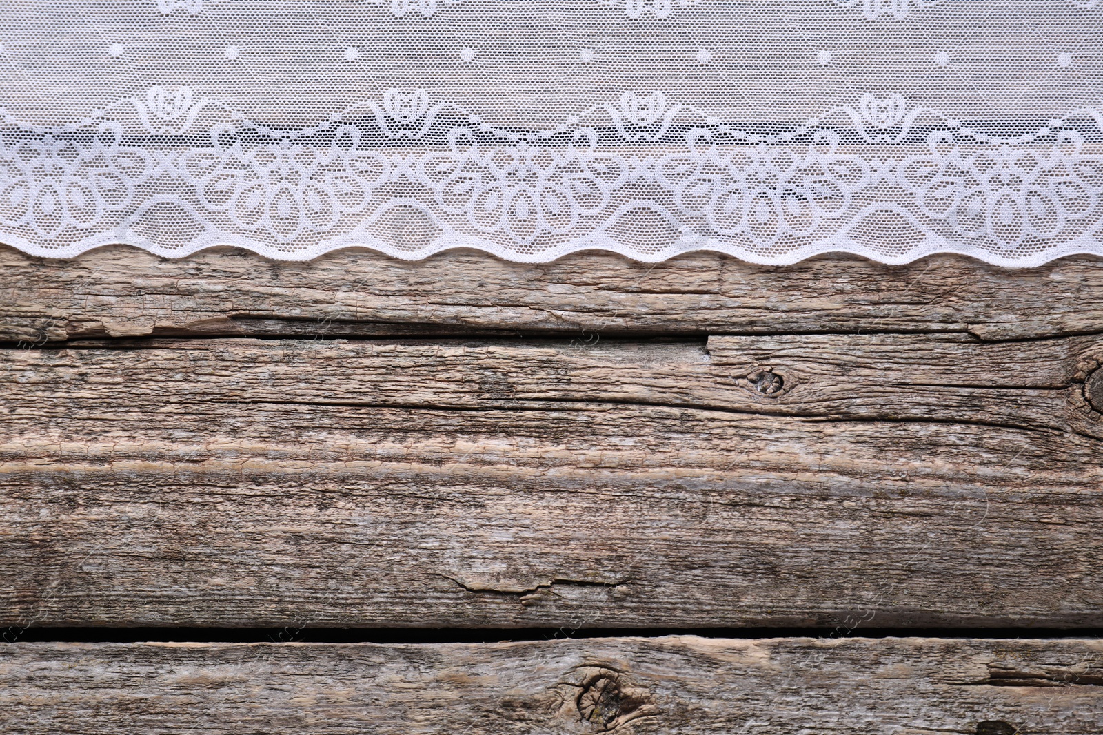 Photo of White lace on wooden table, top view. Space for text