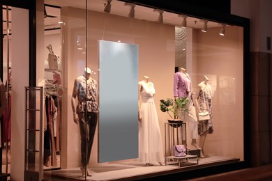 Photo of Beautiful clothes on mannequins in showcases of fashion store