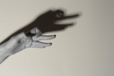 Shadow puppet. Woman making hand gesture like goose on light background, closeup with space for text. Black and white effect