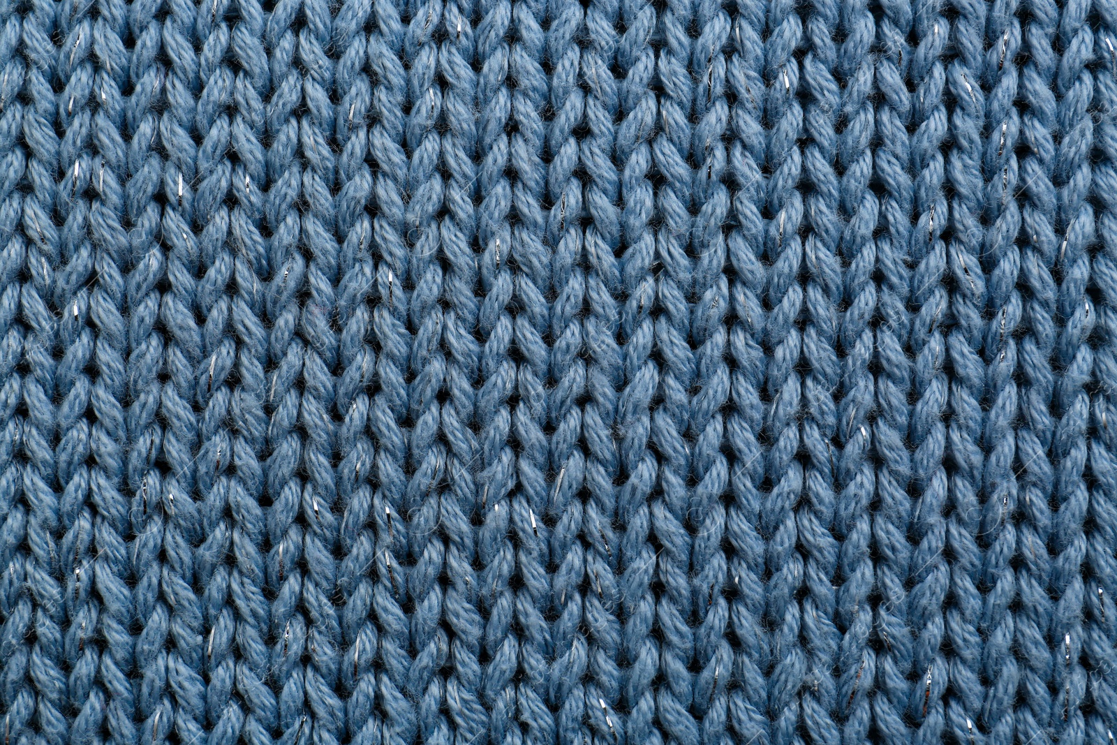 Photo of Beautiful pale blue knitted fabric as background, top view