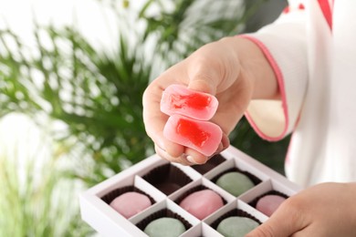 Woman with delicious mochi, closeup. Japanese cuisine