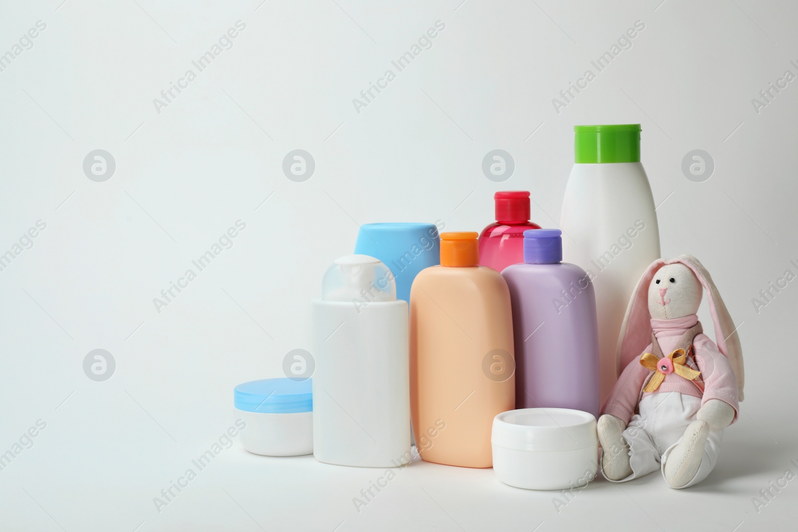 Photo of Baby cosmetic products and toy on white background