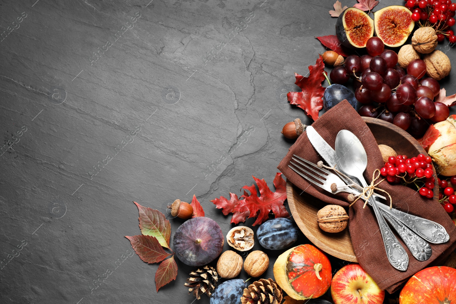 Photo of Flat lay composition with cutlery, autumn vegetables and fruits on grey background, space for text. Happy Thanksgiving day