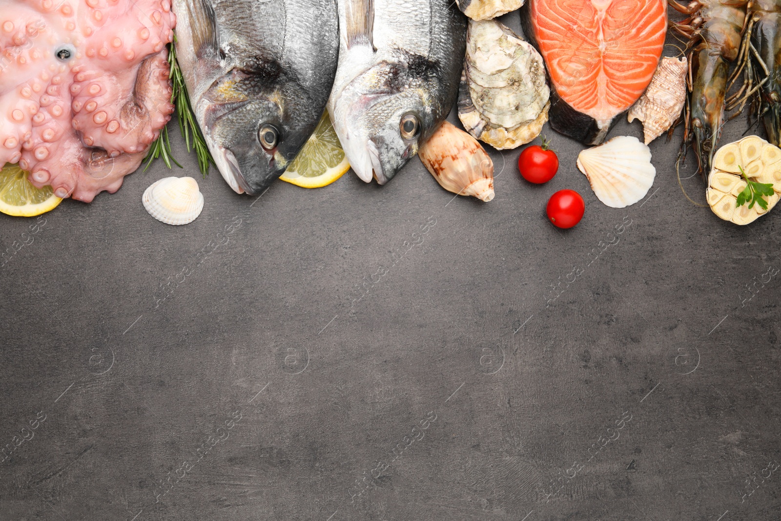 Photo of Flat lay composition with fresh raw dorado fish and different seafood on grey table. Space for text