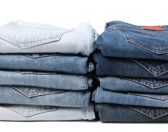 Stacks of different folded jeans isolated on white