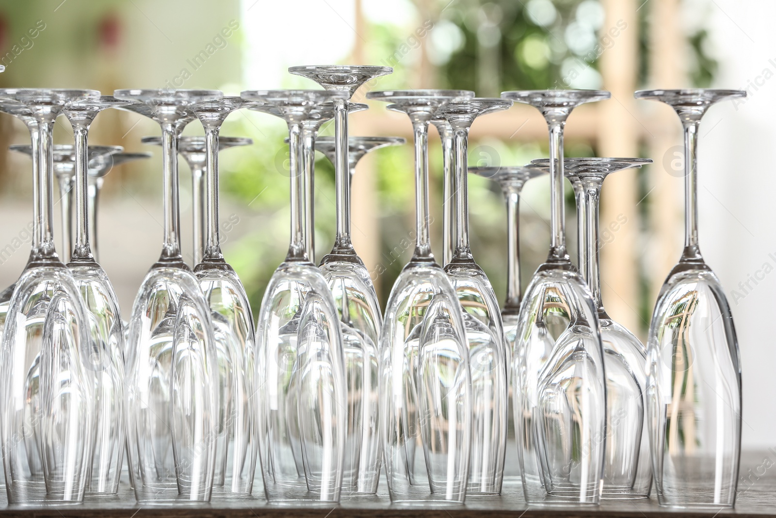 Photo of Empty glasses on wooden table against blurred background