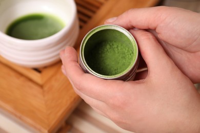 Photo of Woman holding jar with powdered matcha, closeup. Tea ceremony