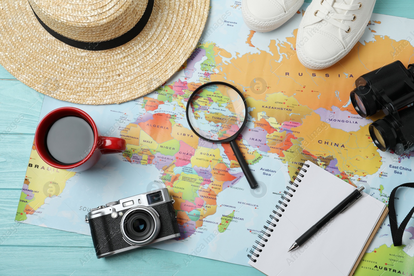 Photo of Flat lay composition with world map and different travel accessories on turquoise wooden table. Planning summer vacation trip