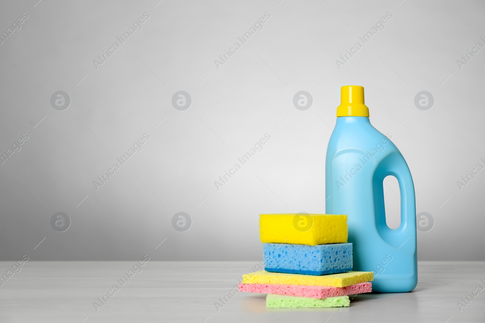 Photo of Bottle of cleaning product and supplies on light table. Space for text