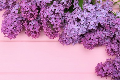 Photo of Beautiful lilac flowers on pink wooden background, top view with space for text