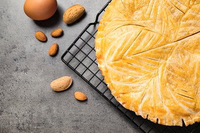 Traditional galette des rois and ingredients on grey table, flat lay