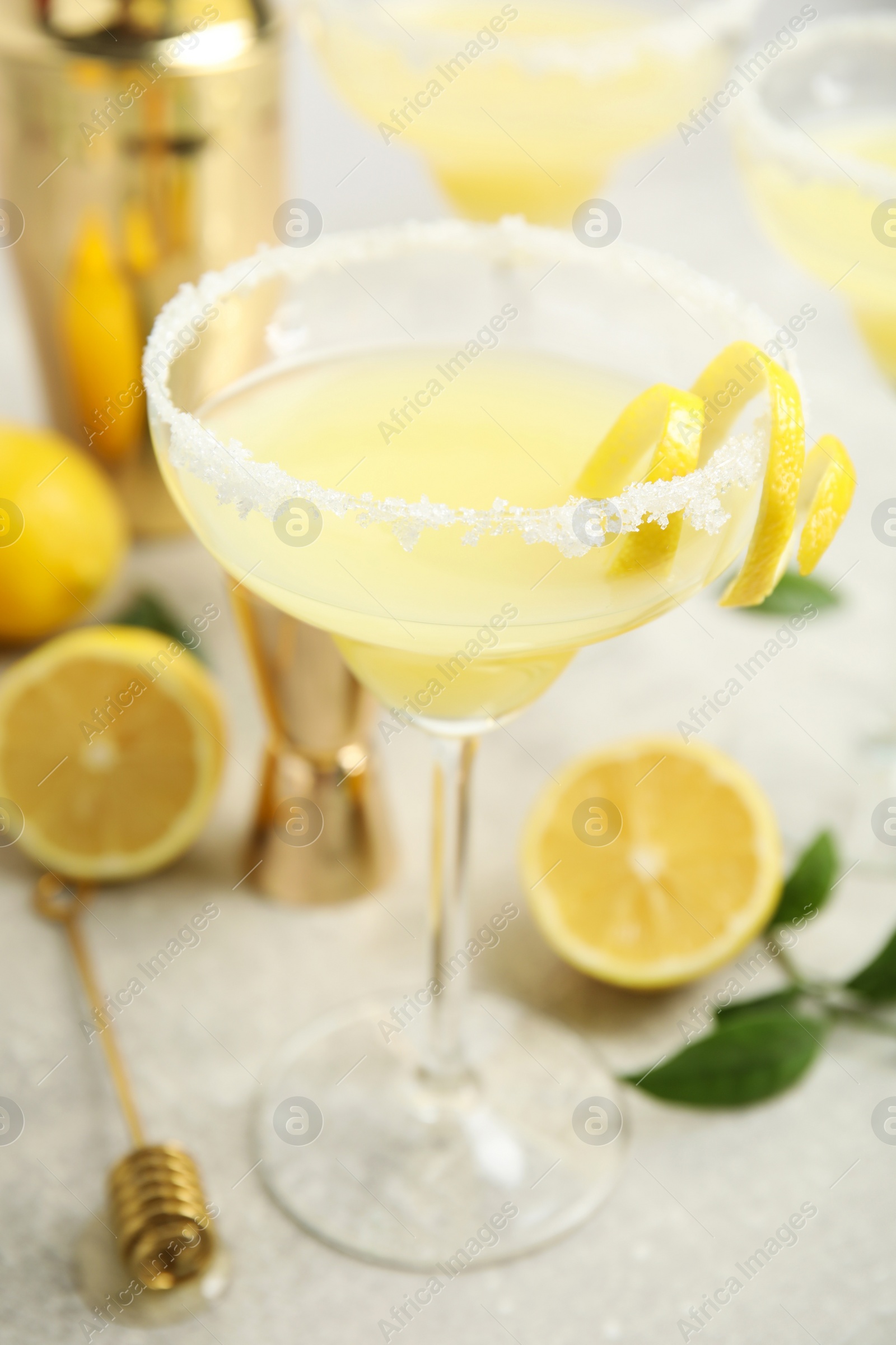 Photo of Delicious bee's knees cocktail and ingredients on light grey table