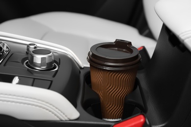 Photo of Takeaway paper coffee cup in holder inside car