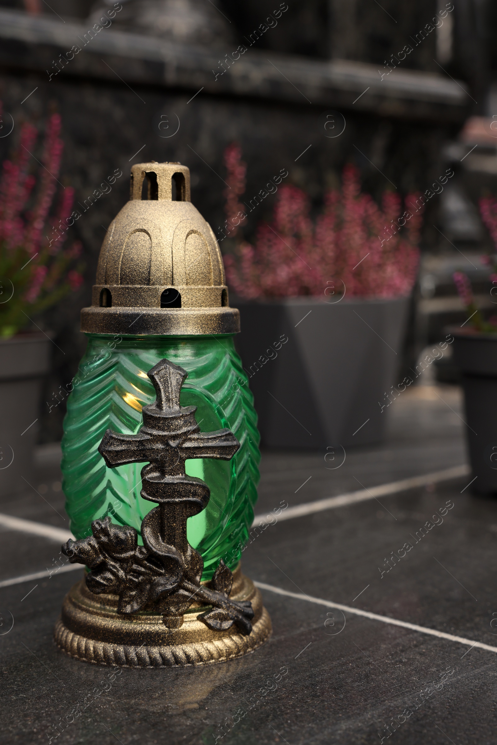 Photo of Grave lantern on black tiled surface at cemetery