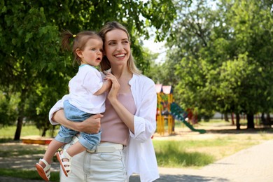 Photo of Happy mother with her daughter spending time together in park. Space for text