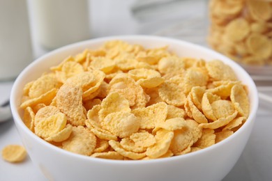 Tasty crispy corn flakes in bowl on table, closeup. Breakfast cereal