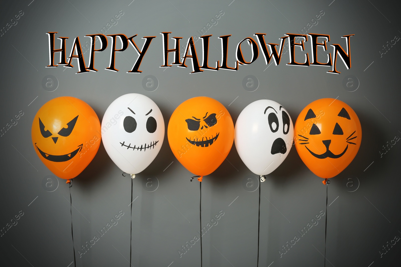 Image of Happy Halloween greeting card design. Color balloons with drawn spooky faces on grey background