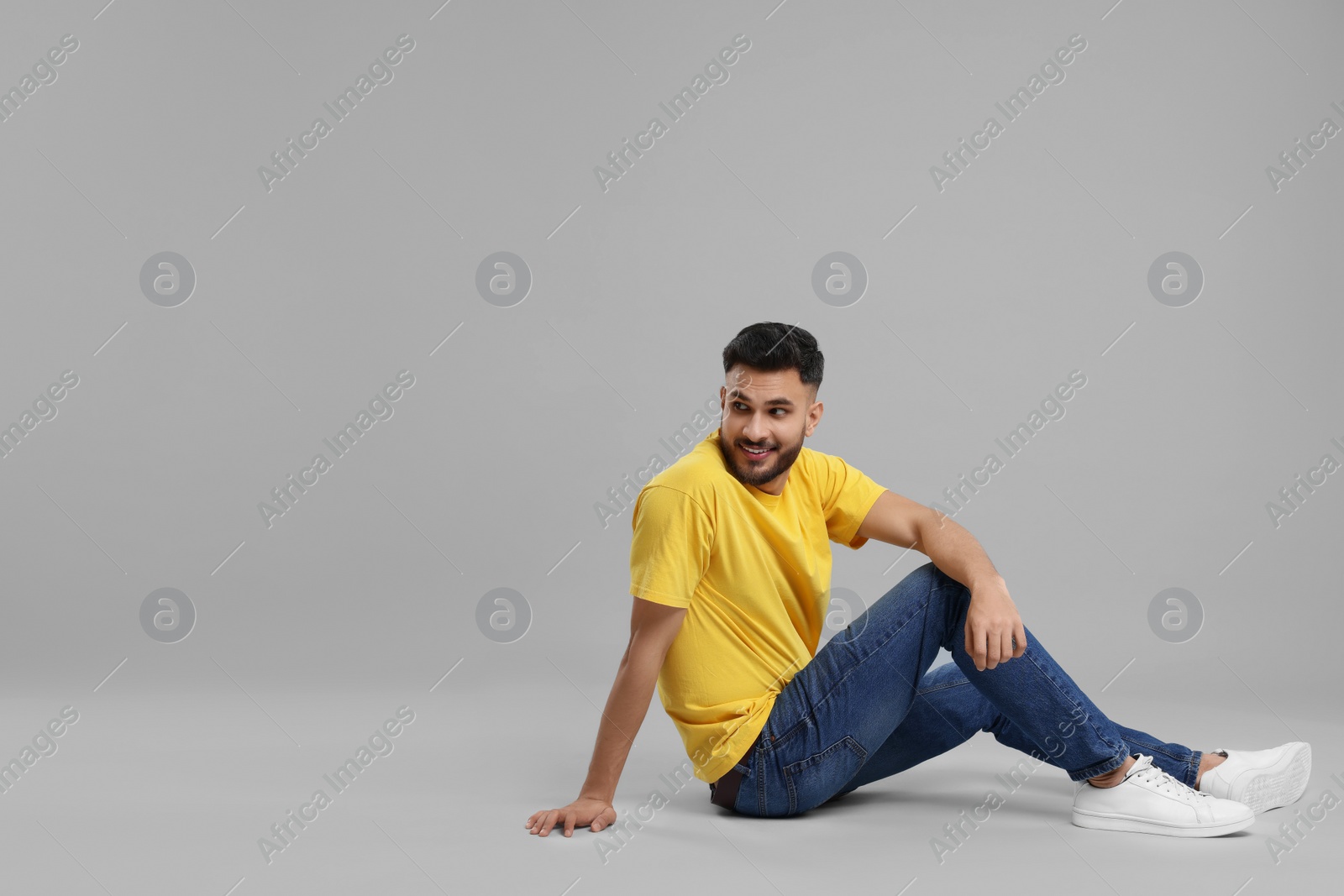 Photo of Handsome young man posing on grey background, space for text