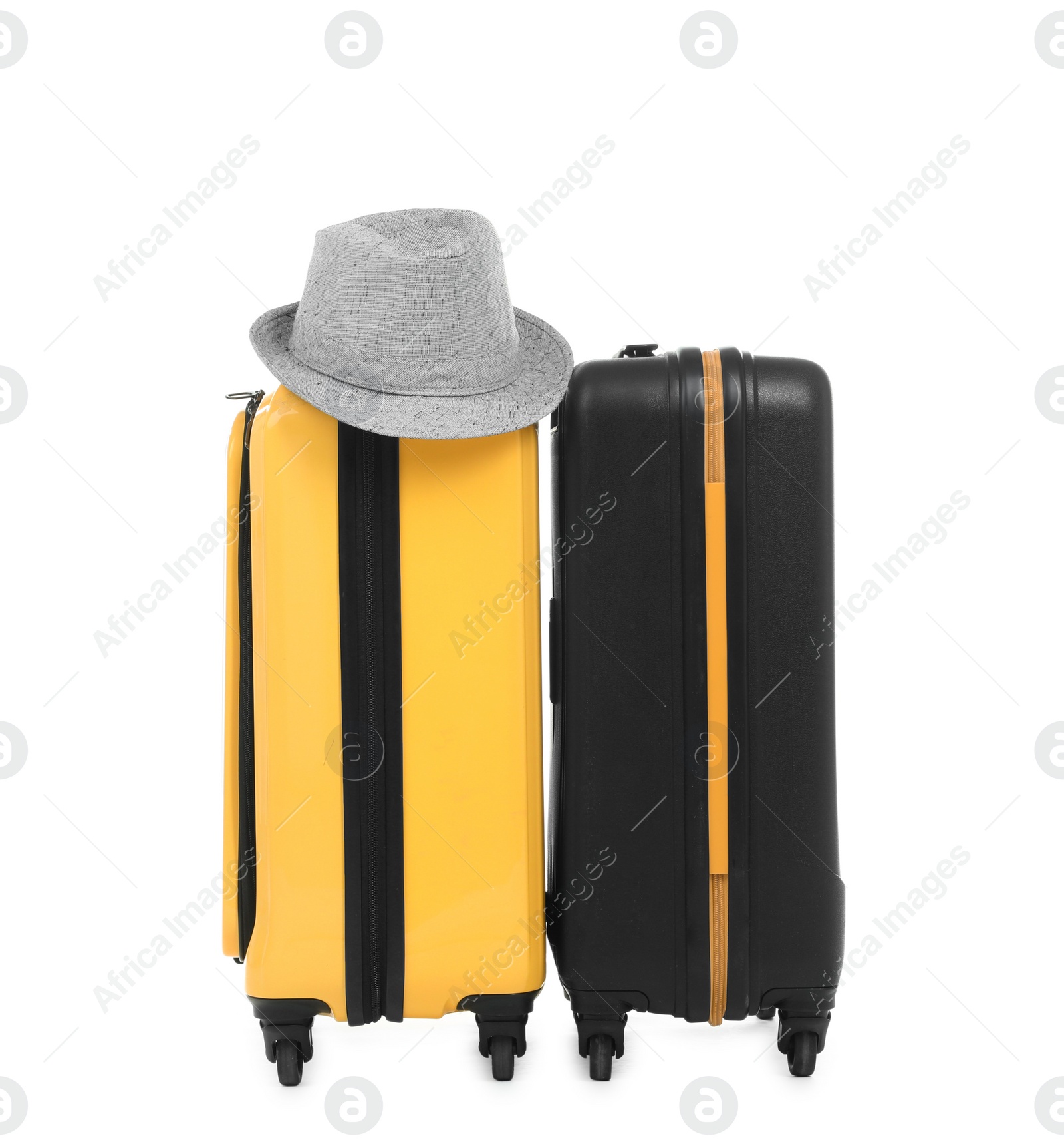 Photo of New suitcases and hat packed for journey on white background