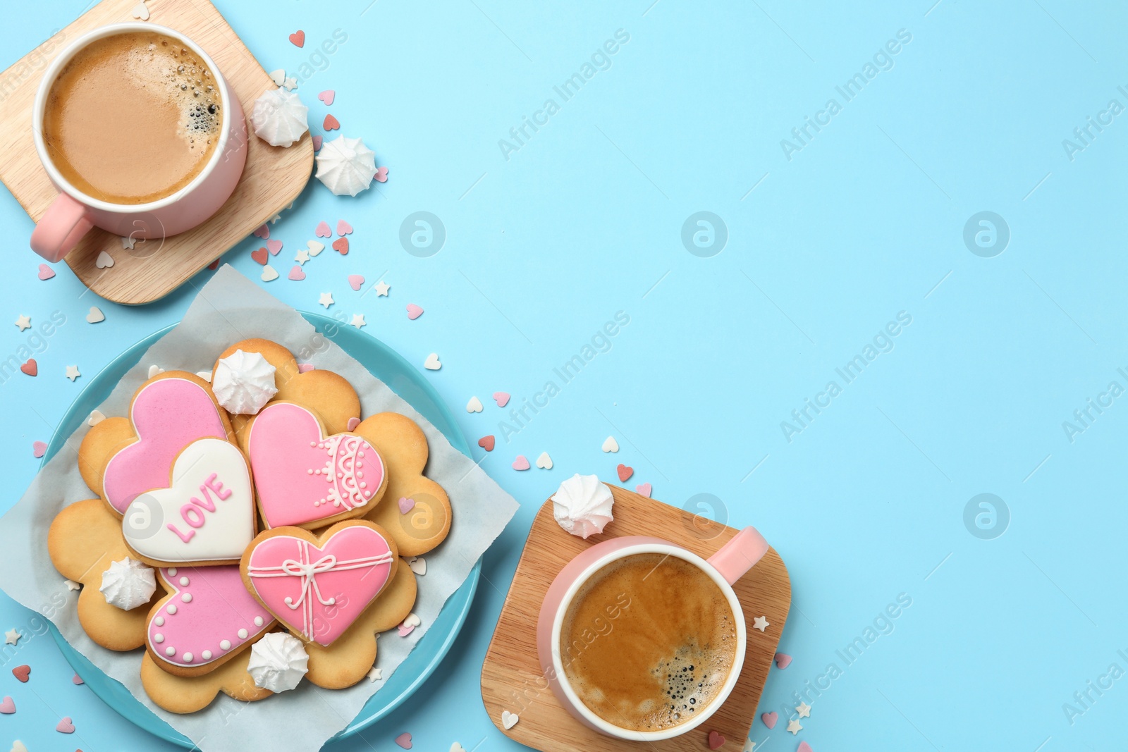 Photo of Romantic breakfast with heart shaped cookies and cups of coffee on color background, flat lay. Space for text