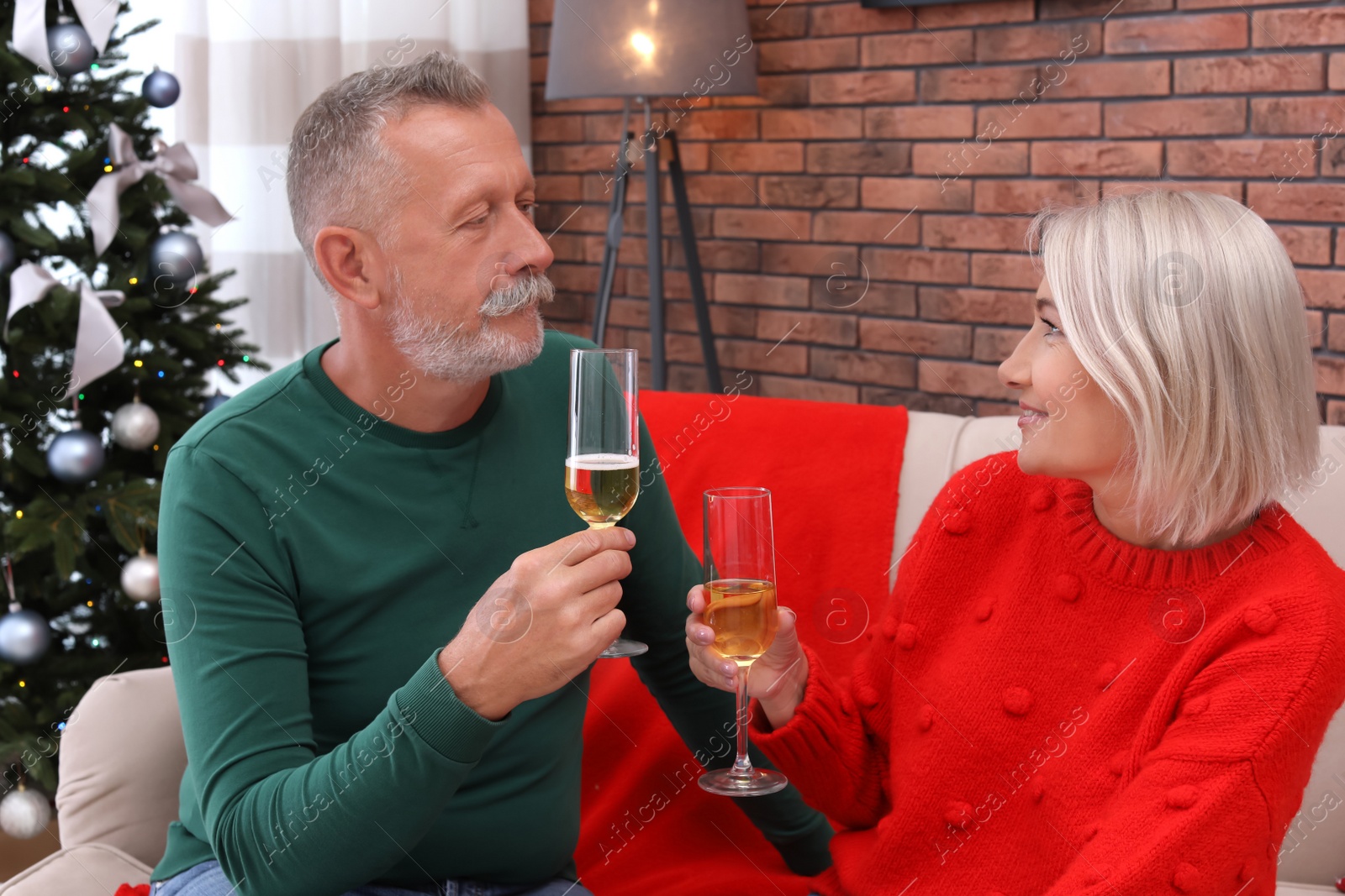 Photo of Mature couple with glasses of champagne at home. Christmas celebration