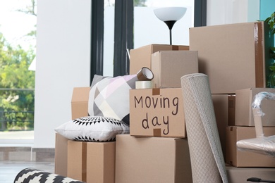 Photo of Cardboard boxes and household stuff in empty room. Moving day