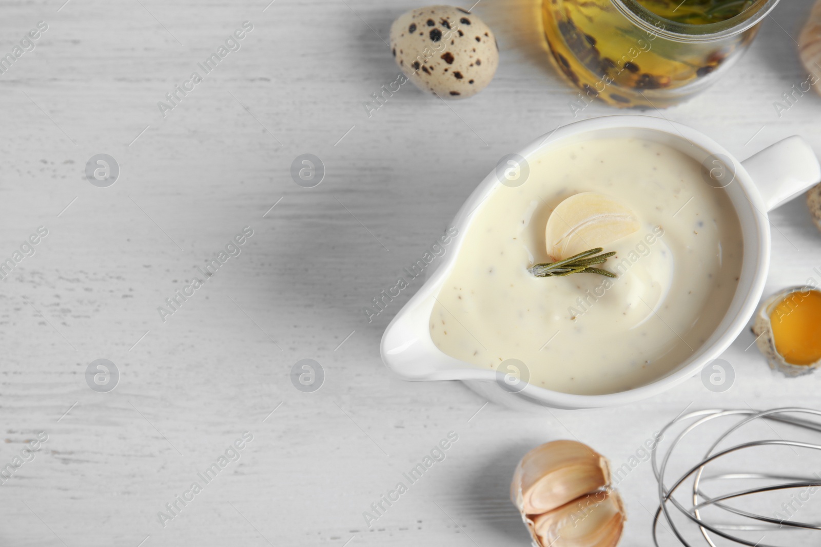 Photo of Flat lay composition with garlic sauce on wooden background. Space for text