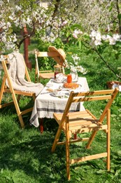 Beautiful table setting with spring flowers in garden on sunny day