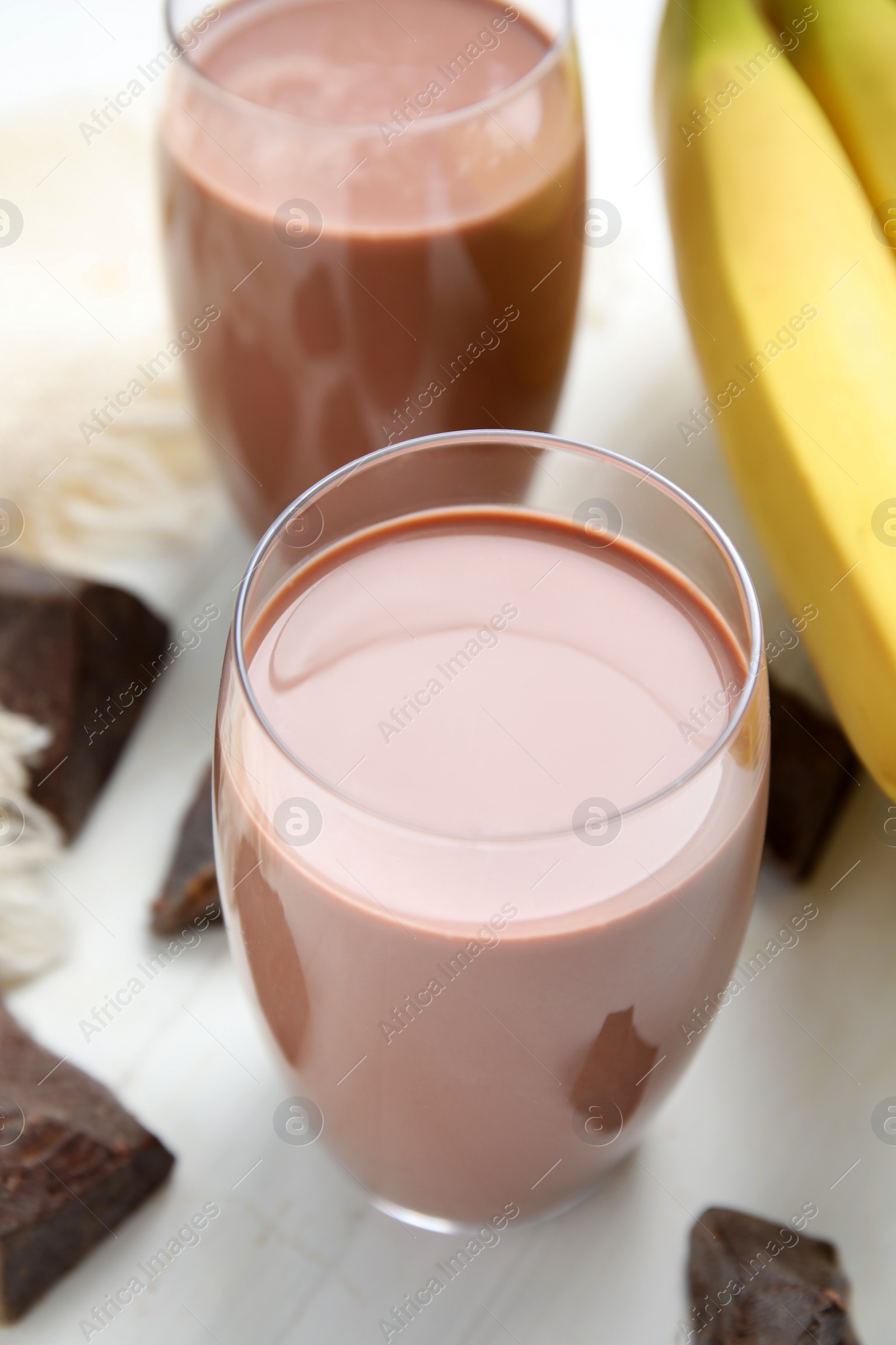 Photo of Fresh yummy chocolate milk on white wooden table, closeup