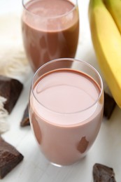 Fresh yummy chocolate milk on white wooden table, closeup