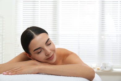 Photo of Beautiful young woman relaxing in spa salon