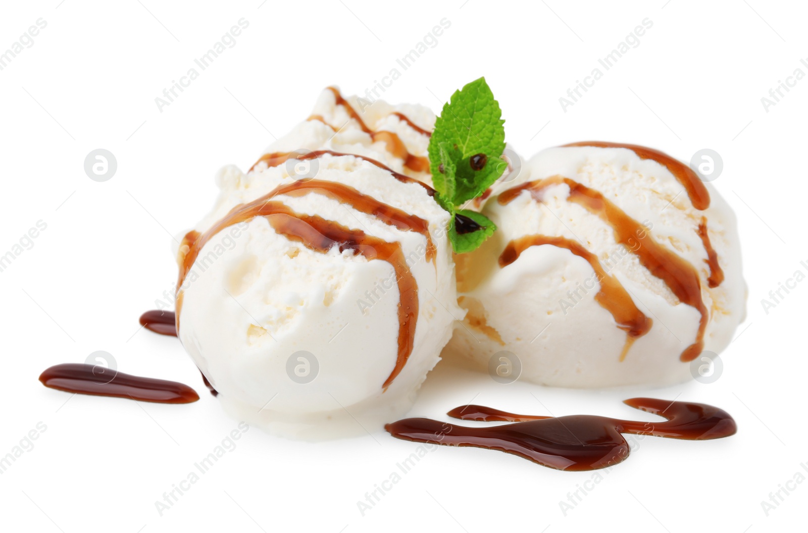 Photo of Scoops of ice cream with caramel sauce and mint isolated on white