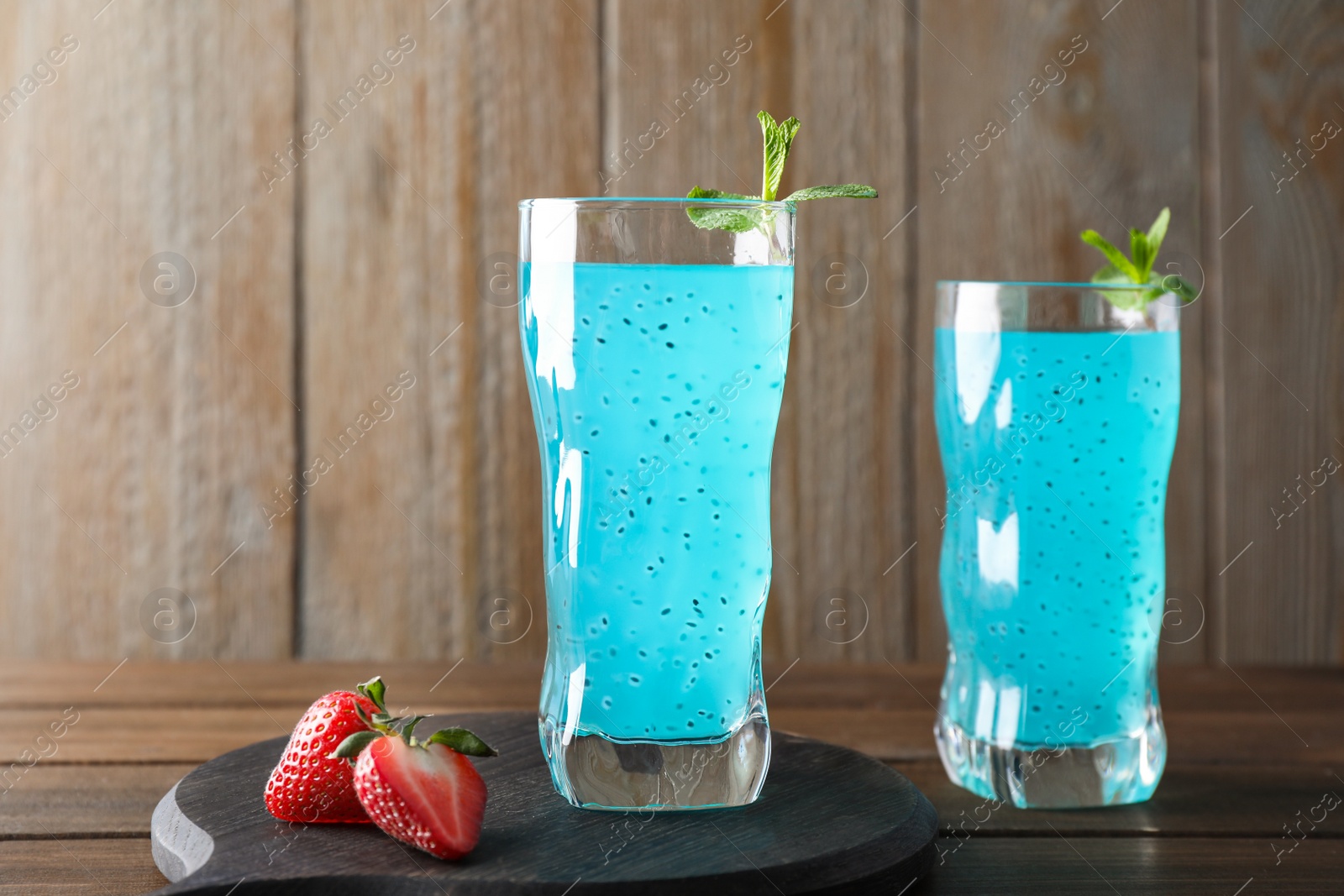 Photo of Delicious cocktail and strawberries on wooden table