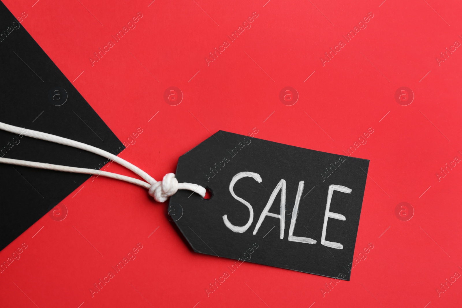 Photo of Tag with word SALE on color background, top view. Black Friday concept
