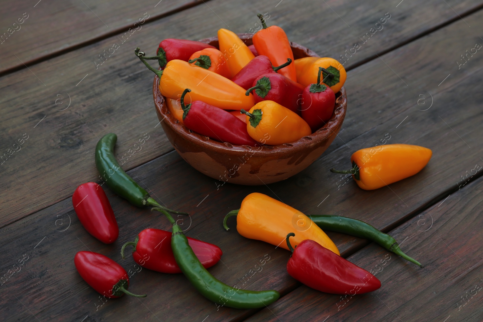 Photo of Different ripe bell peppers on wooden table