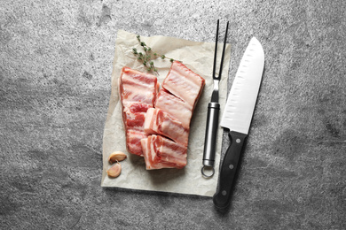 Raw ribs with thyme on grey table, flat lay