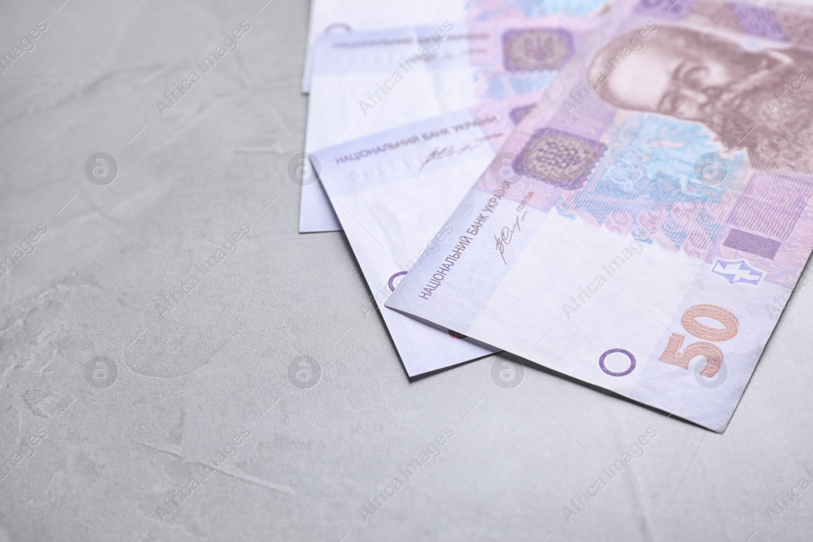 Photo of Ukrainian money on grey background, closeup. Space for text