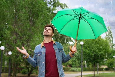 Photo of Man with umbrella outdoors on rainy day