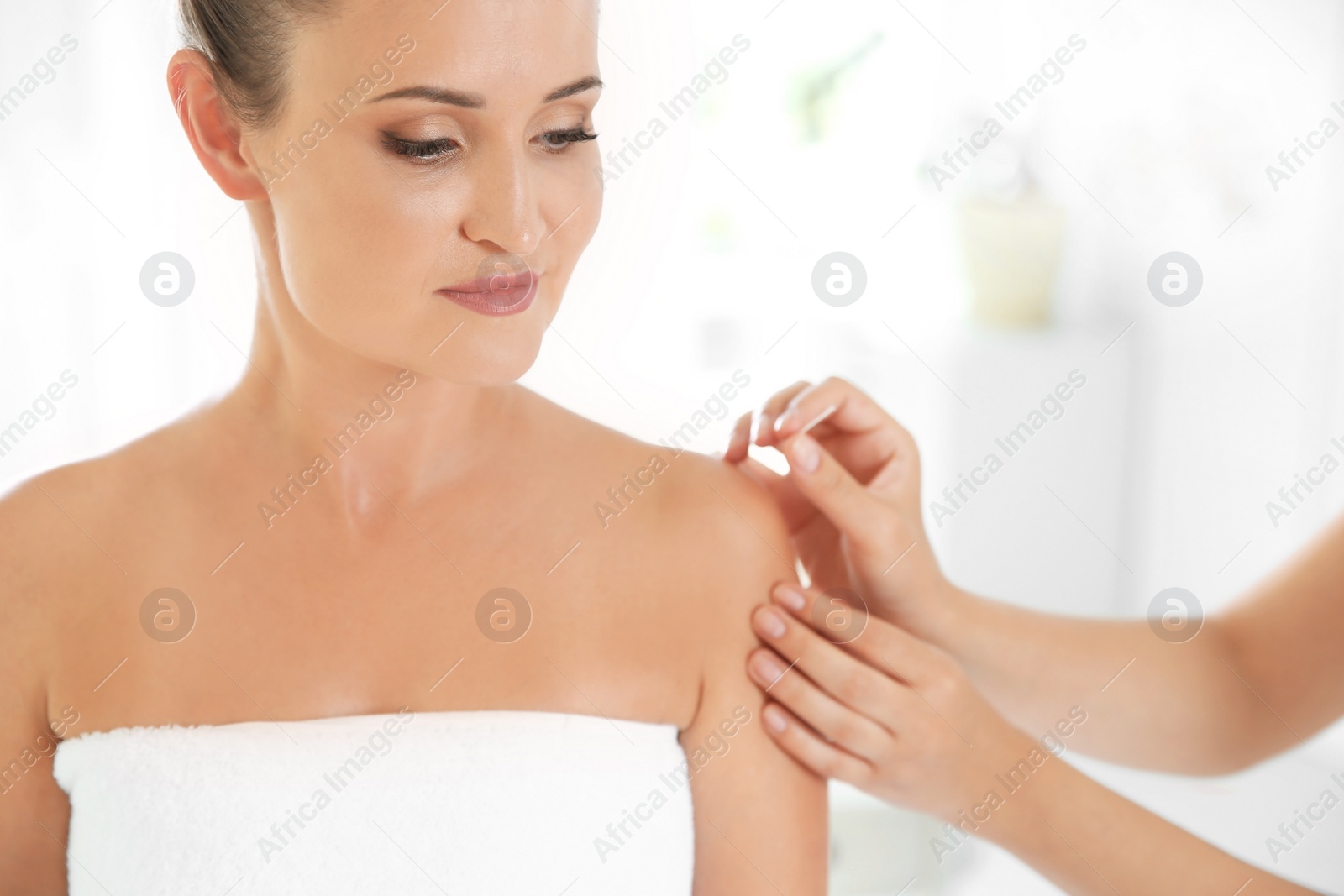 Photo of Young woman undergoing acupuncture treatment in salon