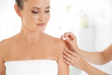 Young woman undergoing acupuncture treatment in salon