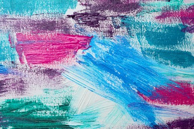 Photo of Strokes of colorful acrylic paints on white canvas, closeup