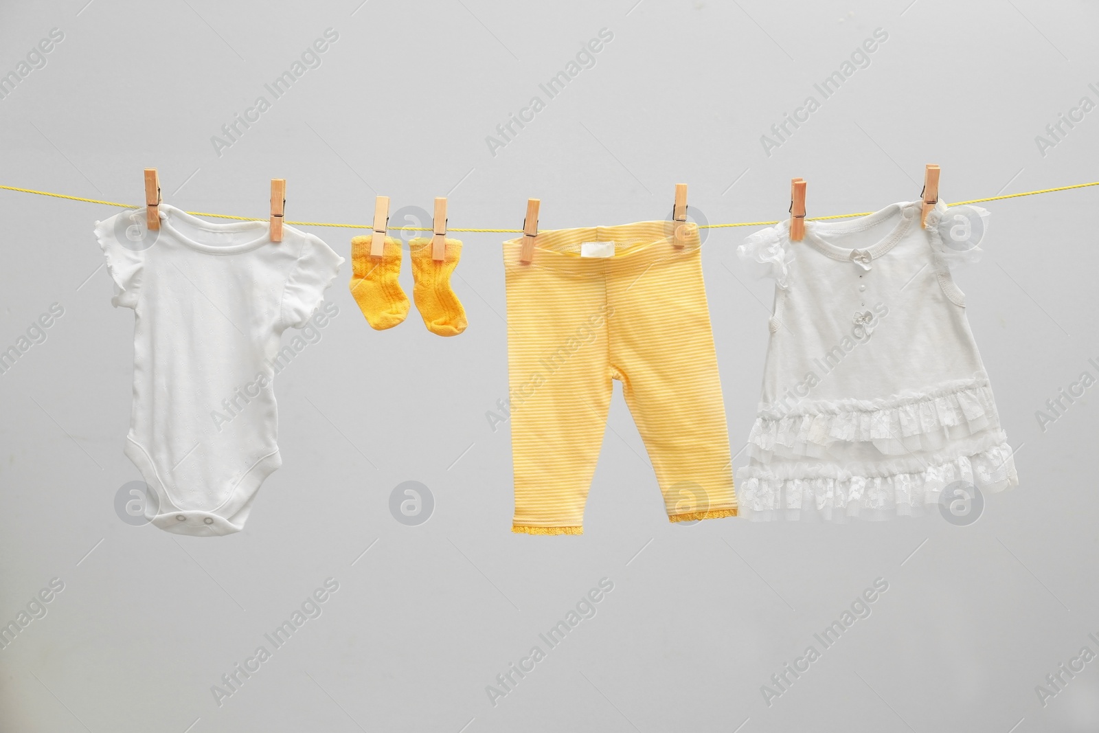 Photo of Children's clothes on laundry line against light background