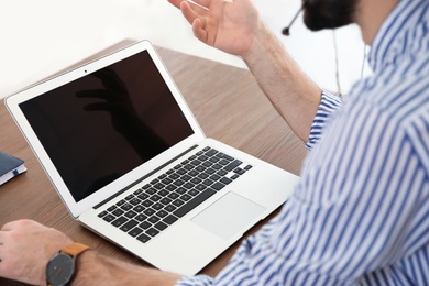 Man using video chat on laptop in home office, closeup. Space for text