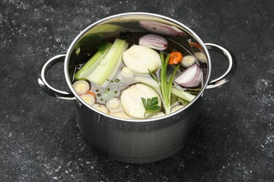 Different ingredients for cooking tasty bouillon in pot on black table