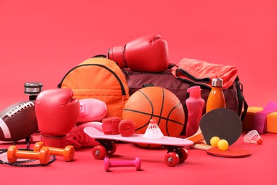 Many different sports equipment on red background