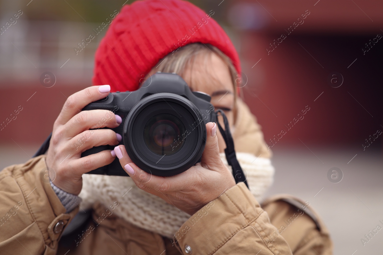 Photo of Photographer taking photo outdoors, focus on camera