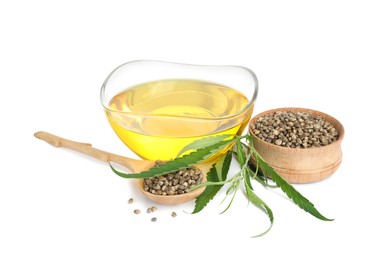 Photo of Hemp oil, fresh leaves and seeds on white background
